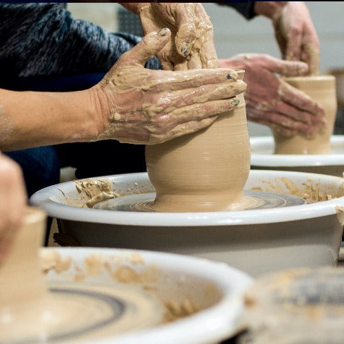 Picture of hands throwing pots on the potter wheel.